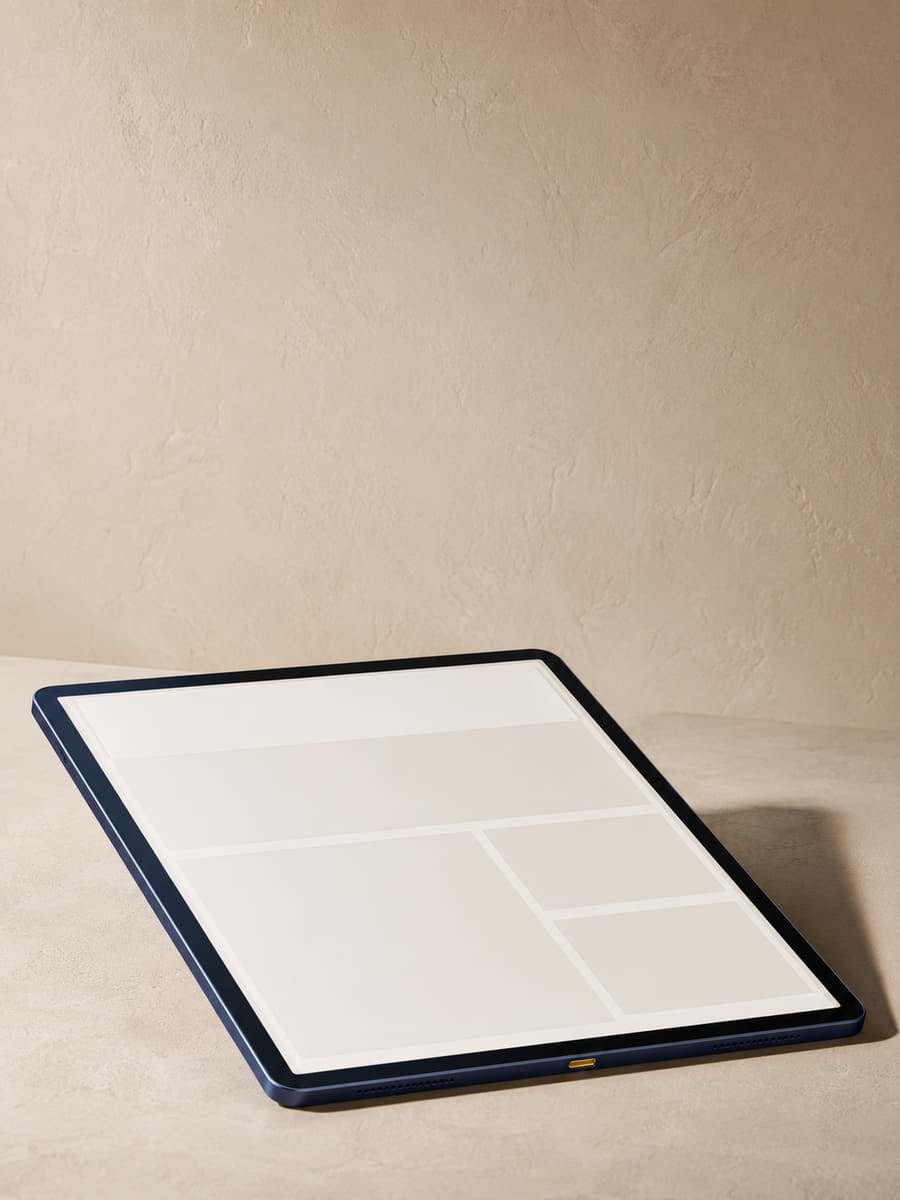 A navy-cased tablet resting on a pale stone surface, showing the bare column grid of a Montlior digital edition.